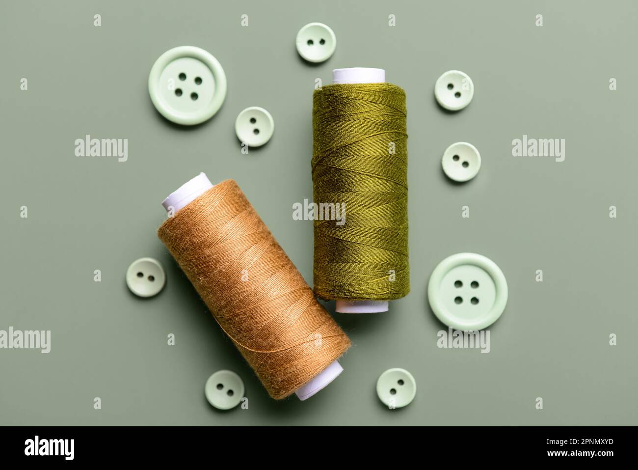 Composition with thread spools and buttons on grey background Stock Photo