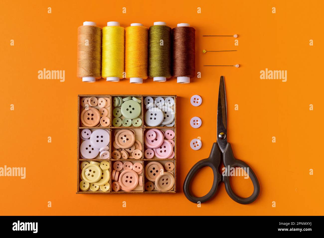 Composition with different thread spools and sewing supplies on color background Stock Photo