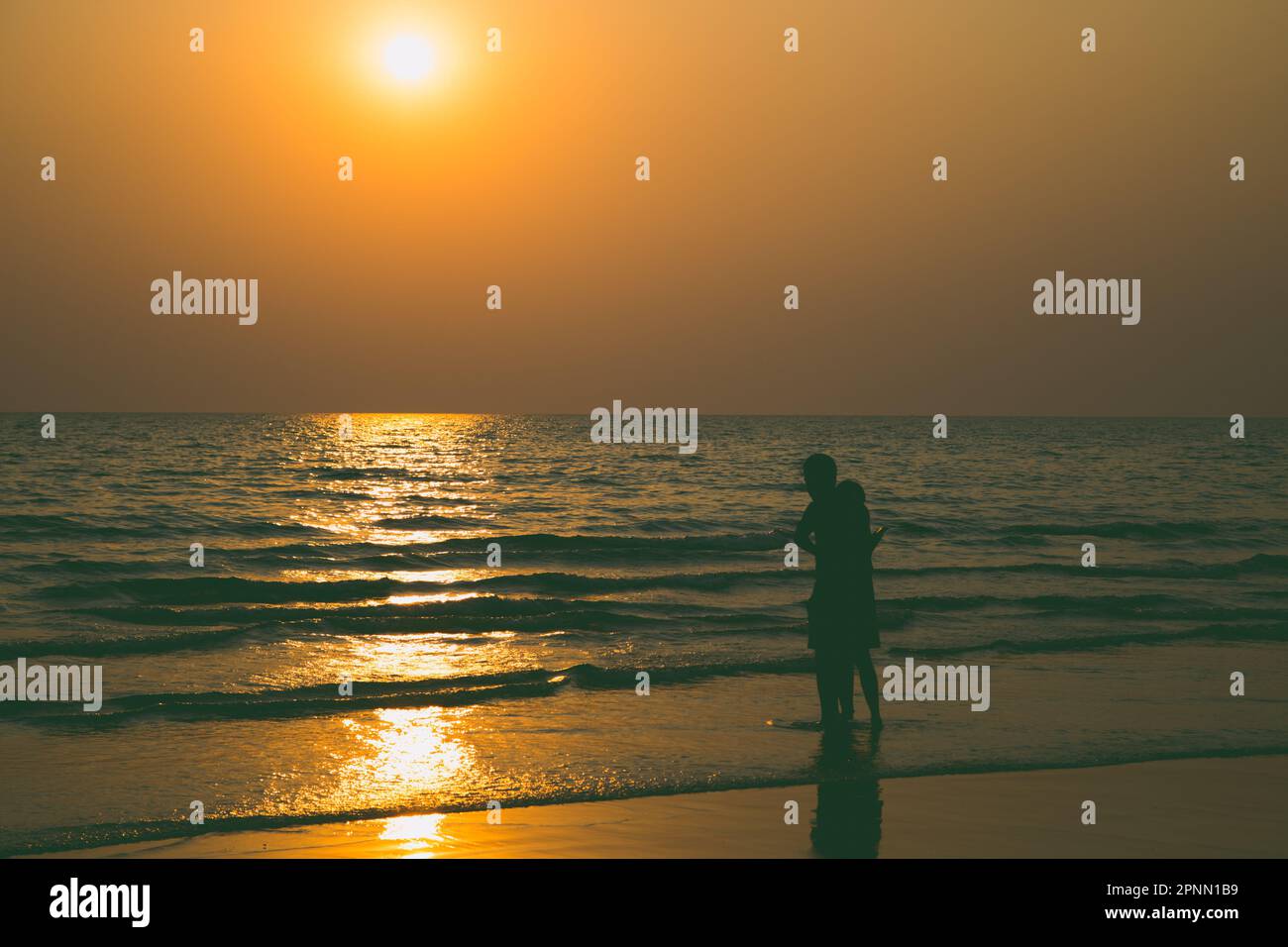 Siluate lovers and beach before sunset background Stock Photo