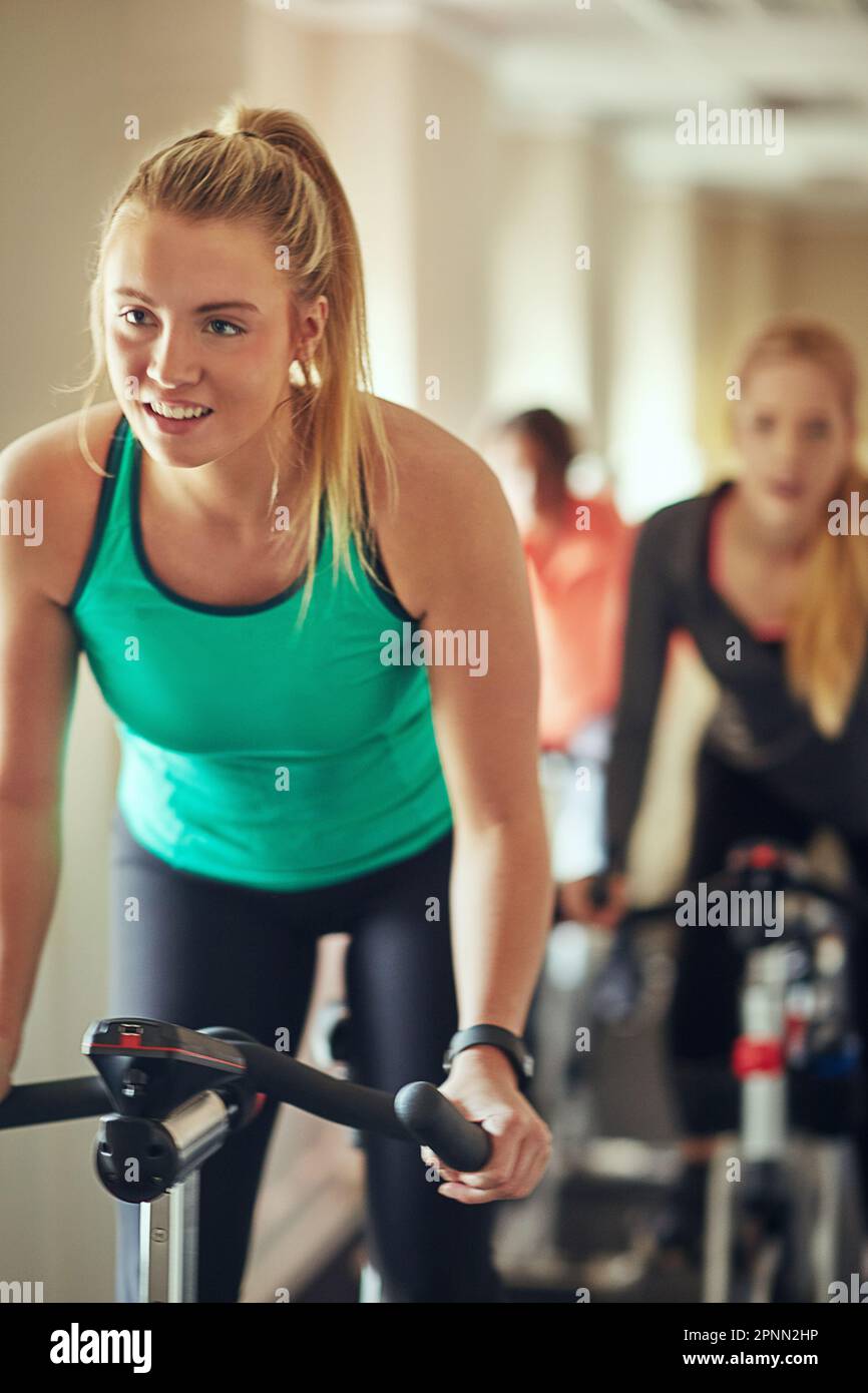 Spin the calories away. a young woman working out with an exercise bike