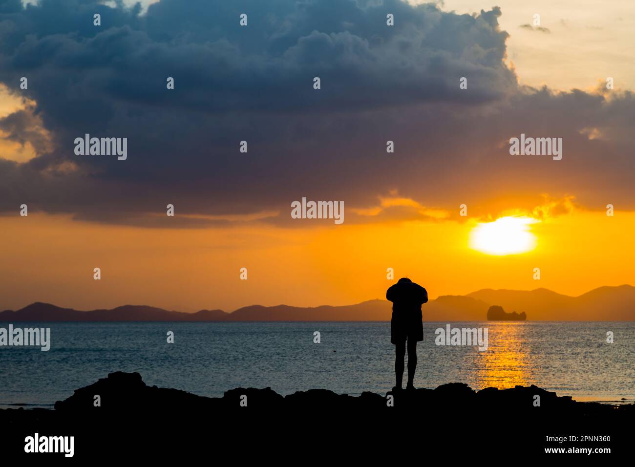 Siluate lonely man at the beach before sunset background Stock Photo