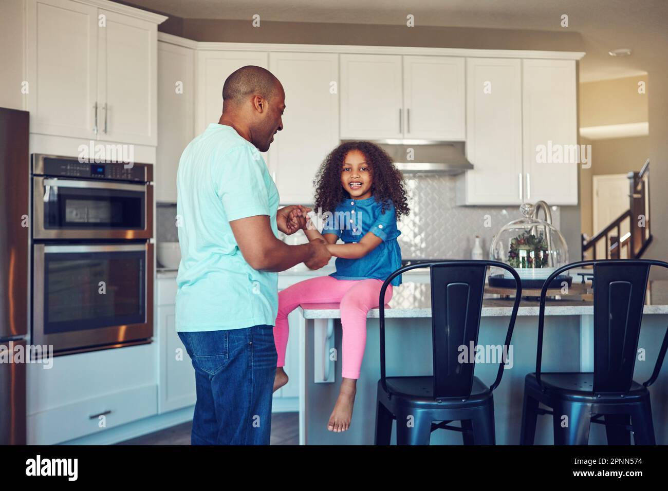 Ive got daddy wrapped around my finger. a happy little girl and her father bonding in the kitchen at home. Stock Photo