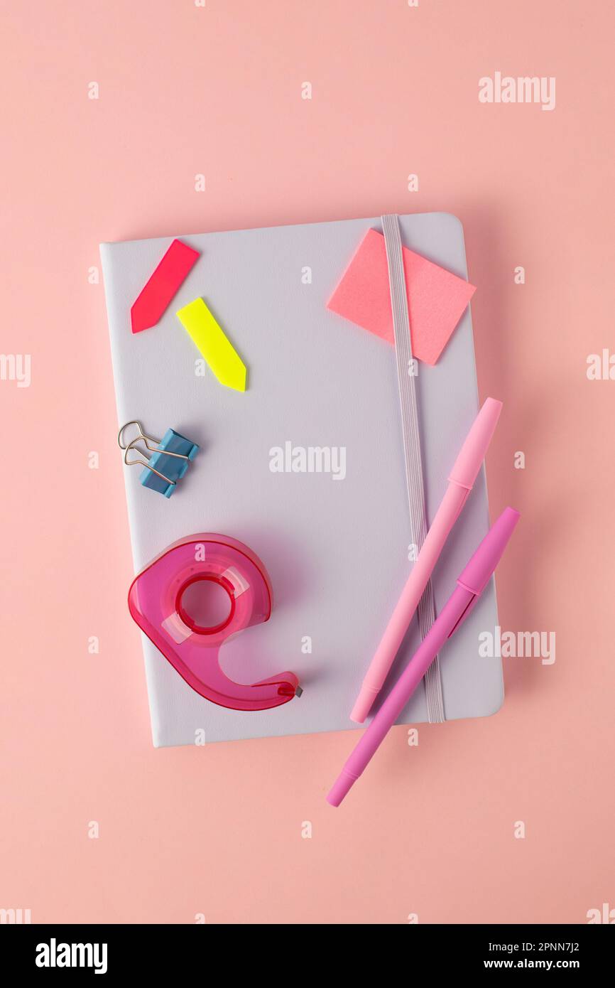 Flat notebook and stylish stationery for school and office on a pink