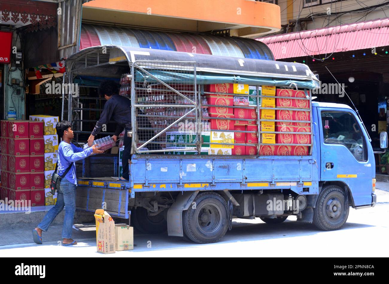 People unload cases of drinks, including beer, from a truck to stock up a shop in Jomtien, Pattaya, Thailand, Asia. This is the day after the end of the Songkran water festival in Pattaya, during which sales of all drinks are very high as it is a major holiday in Thailand. Stock Photo