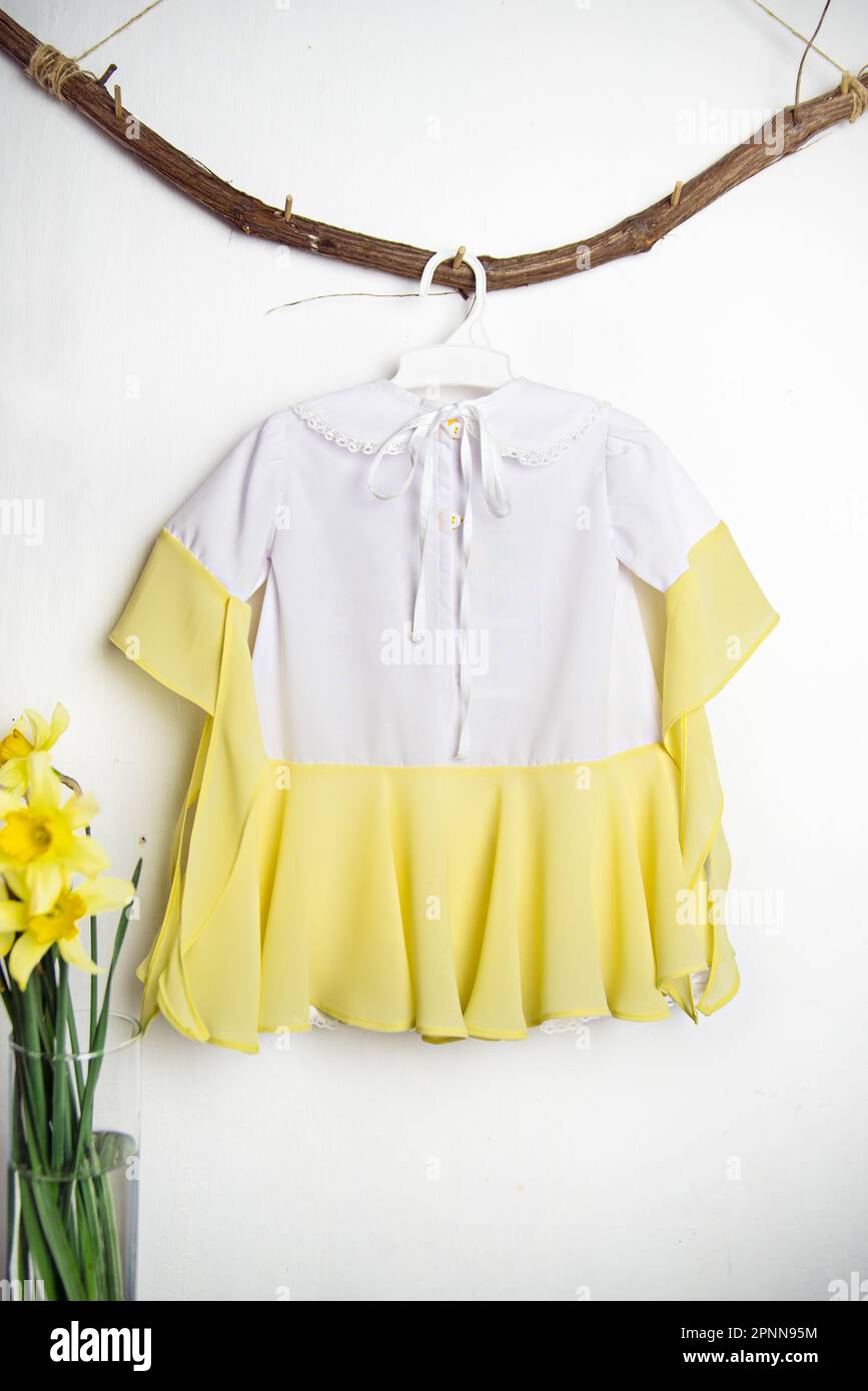 Children's dress, outfit for a photo shoot, cute dress for a 1 year old baby girl white with yellow, view from the back Stock Photo