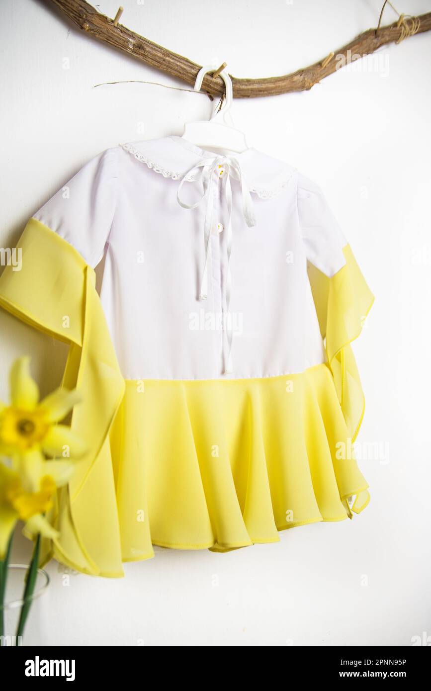 Children's dress, outfit for a photo shoot, cute dress for a 1 year old baby girl white with yellow, view from the back Stock Photo