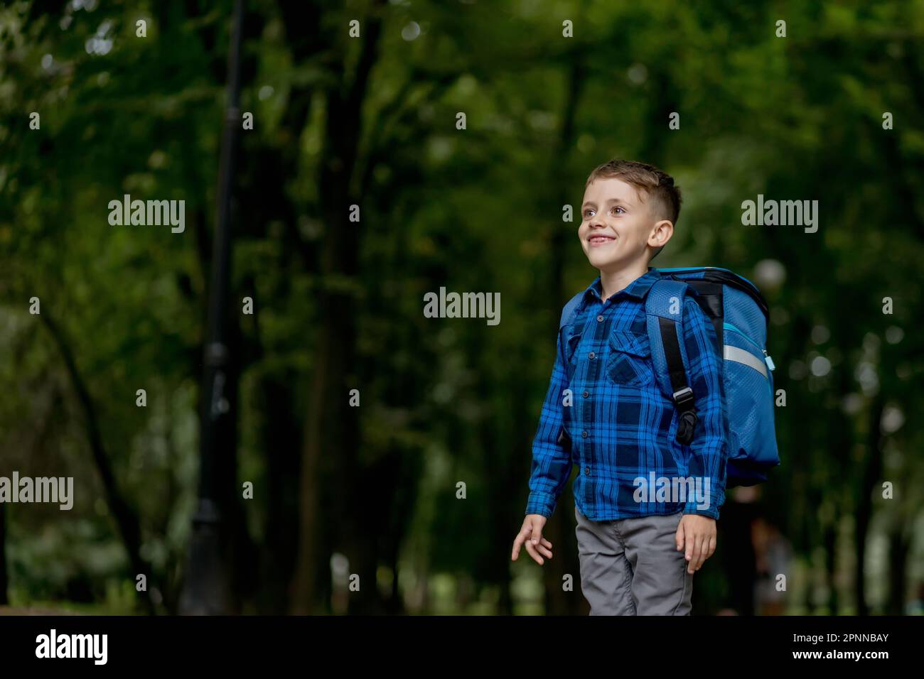 Portrait of a first grader with a backpack. The boy goes to school