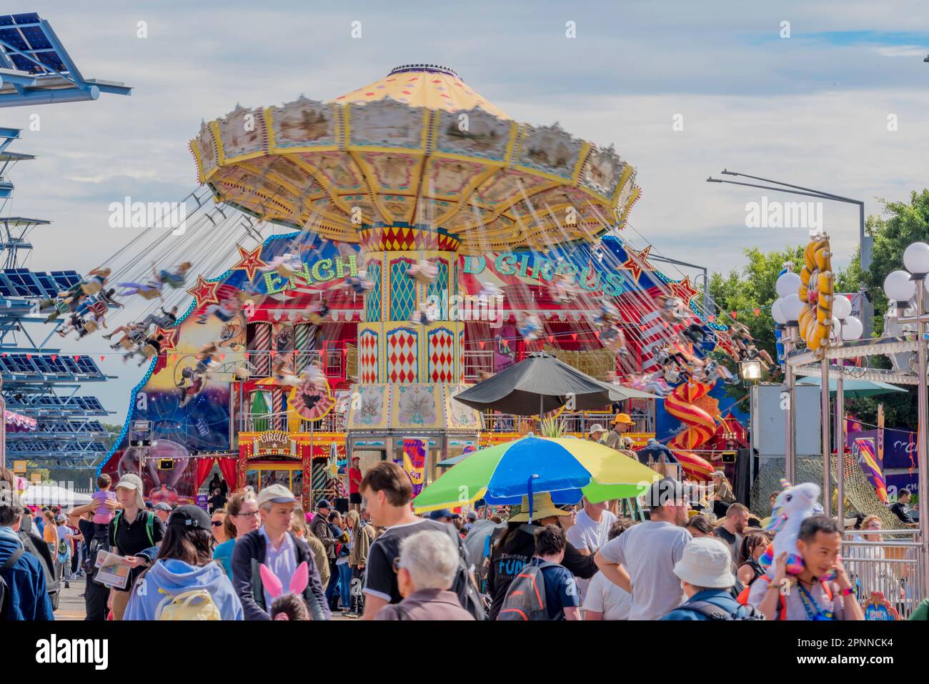 Crowds of people walk past and enjoy riding on the many fun and colourful rides at the 2023  Royal Easter Show in Sydney, Australia Stock Photo