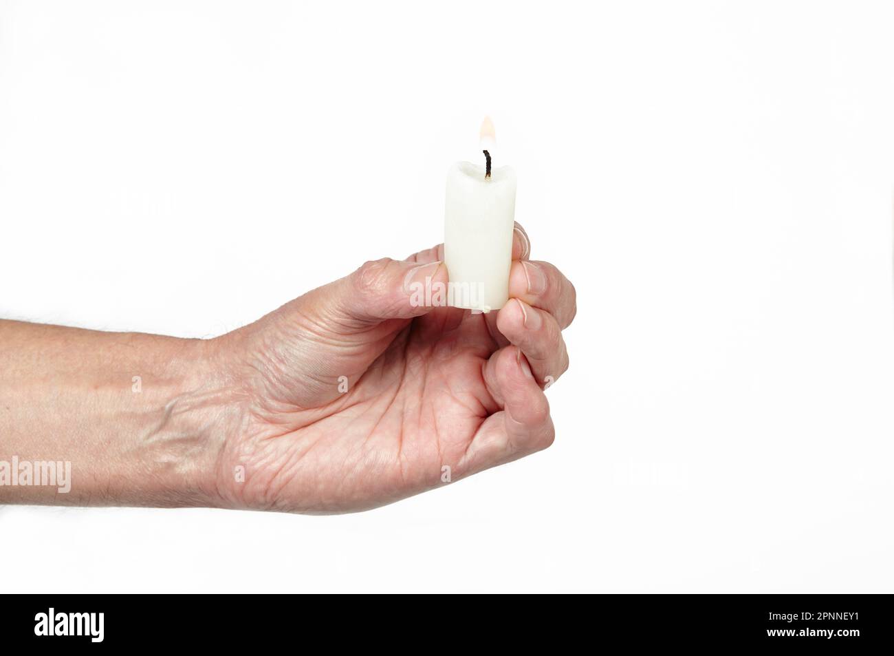 Men's hand holding a candle isolated white background. Man holding burning candle, closeup Stock