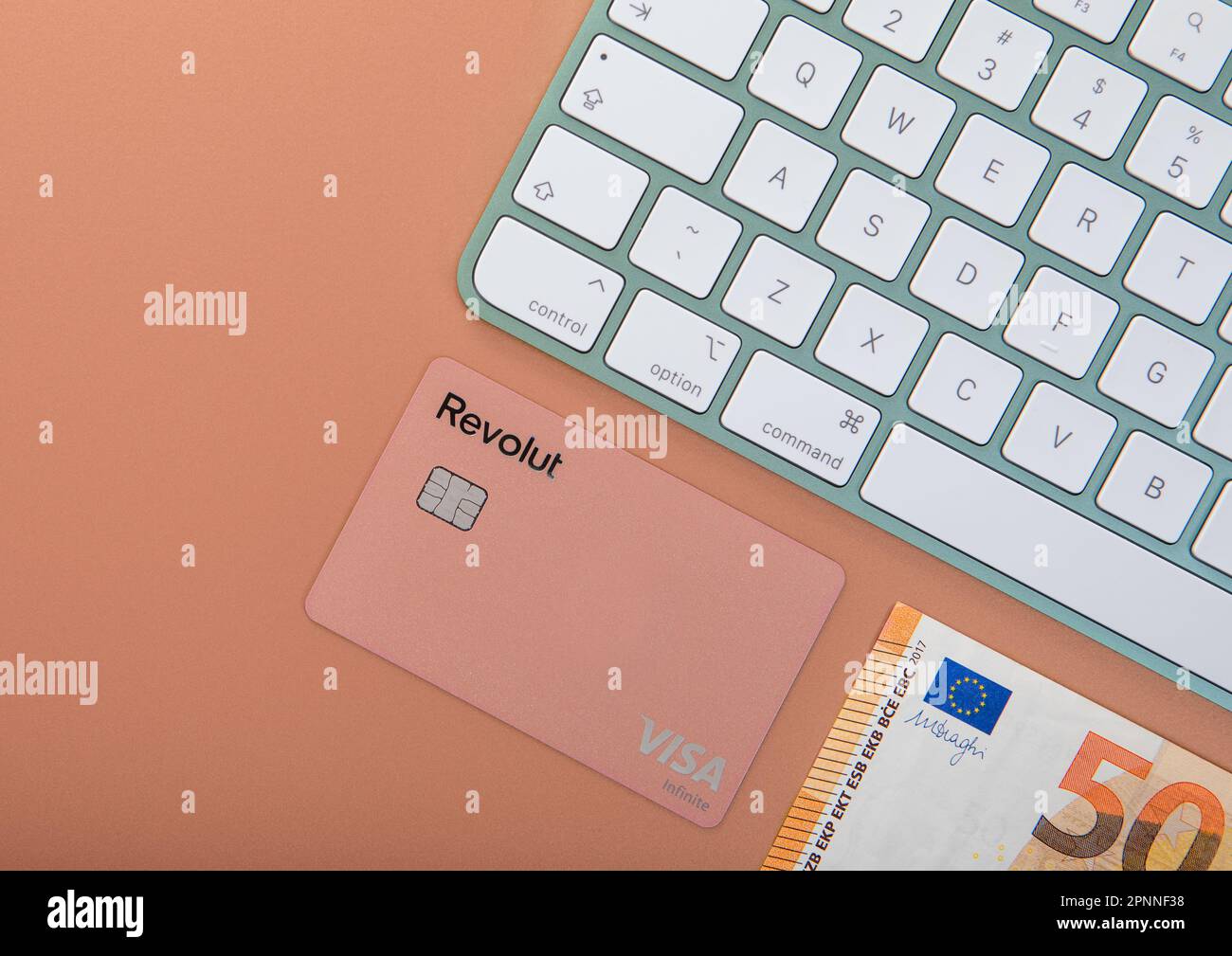 LONDON,UK - NOVEMBER 12, 2022: Revolut visa card with fifty euro bill and keyboard for online banking. Top view. Stock Photo
