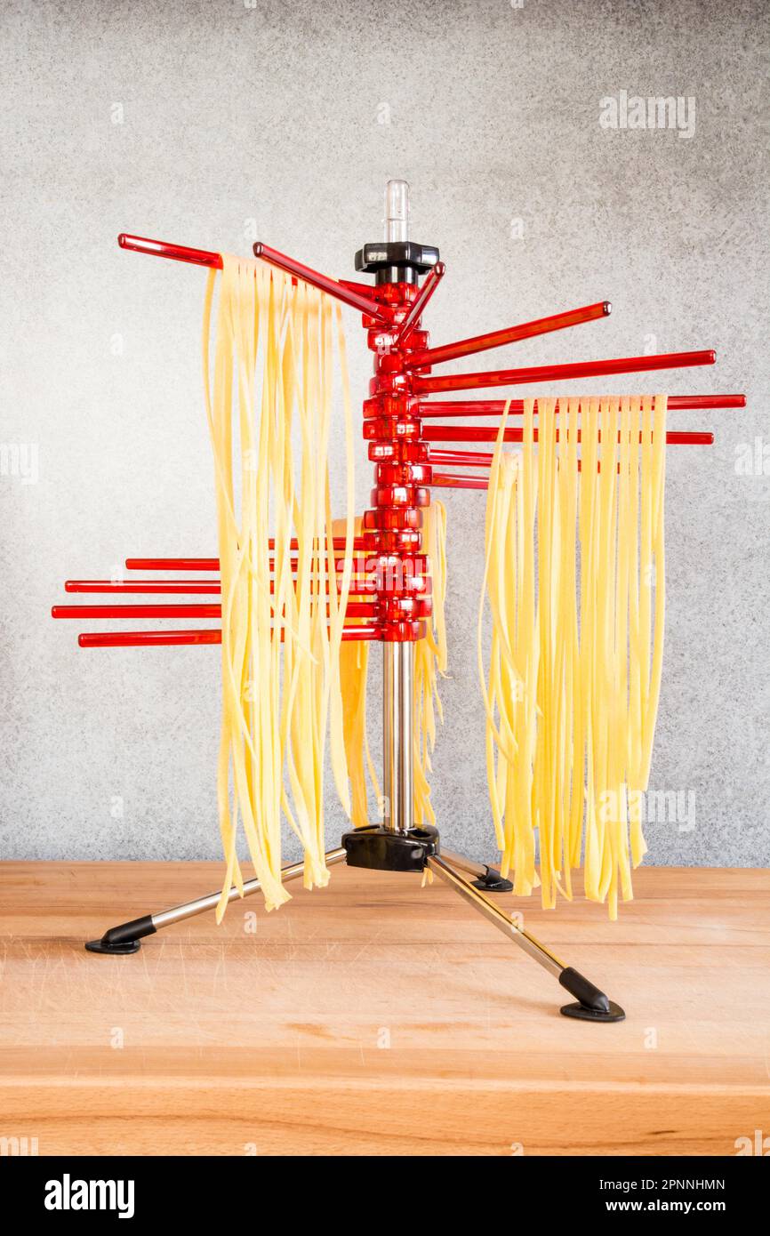 Selfmade italian tagliatelle hanging on a pasta drying rack Stock