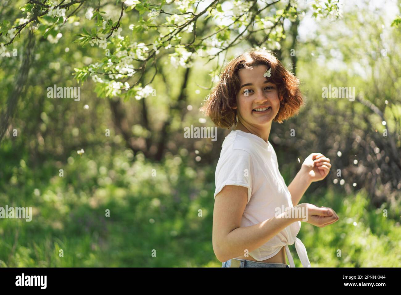 Beautiful teenage girl with spring flowers enjoying nature and laughing ...