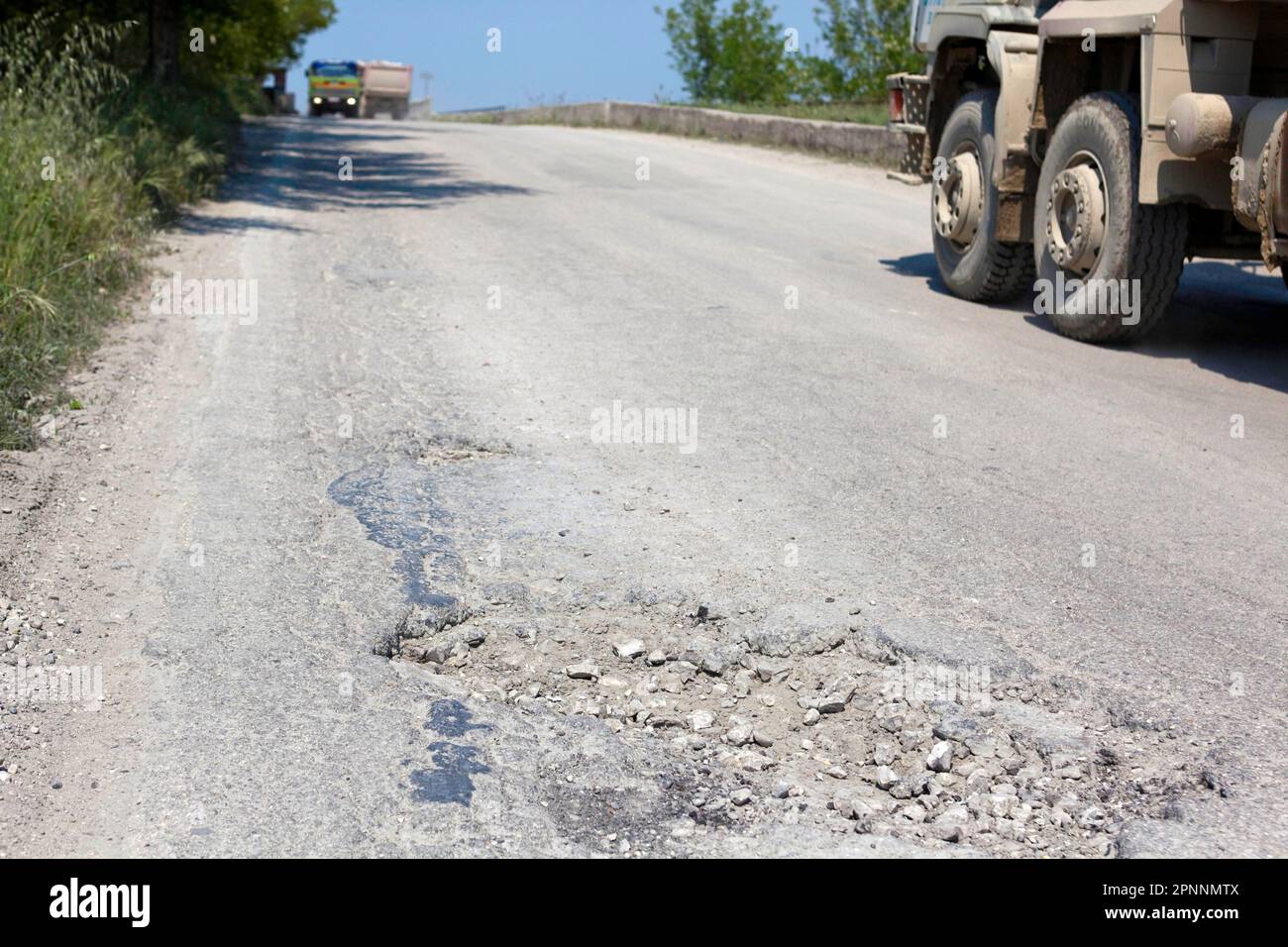 Bumpy road with pothole, poor infrastructure, Novosele, Qark Vlora, Albania Stock Photo