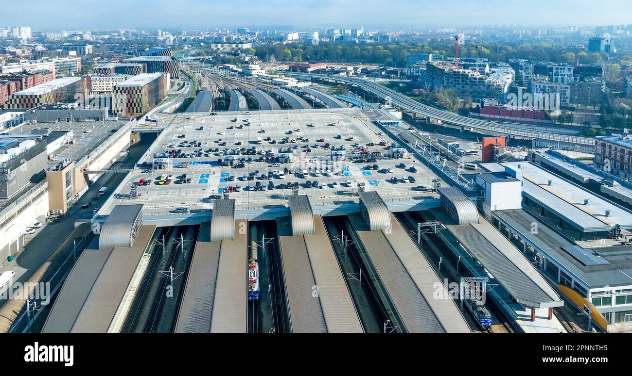 Main railway station (Krakow Glowny) in Krakow, Poland, with a big parking lot on the roof, cars, roofed platforms, railroad tracks, trains and electr Stock Photo