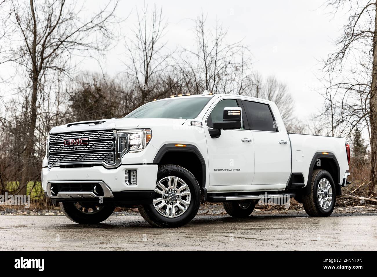 A white GMC truck parked on a concrete surface in a natural setting. Stock Photo