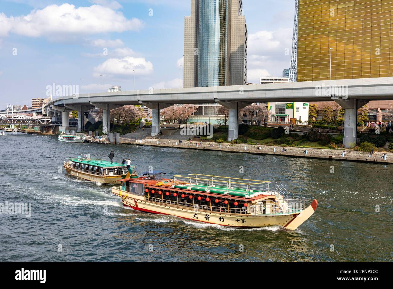 Tokyo Sumida River boats pass Tokyo Sky Tree and Asahi offices and beer hall, Tokyo,April 2023,Japan,Asia Stock Photo