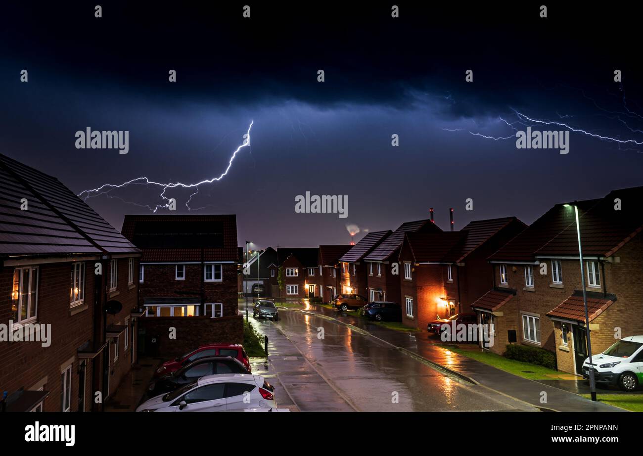 A vivid lightning strike illuminating an urban landscape at night ...