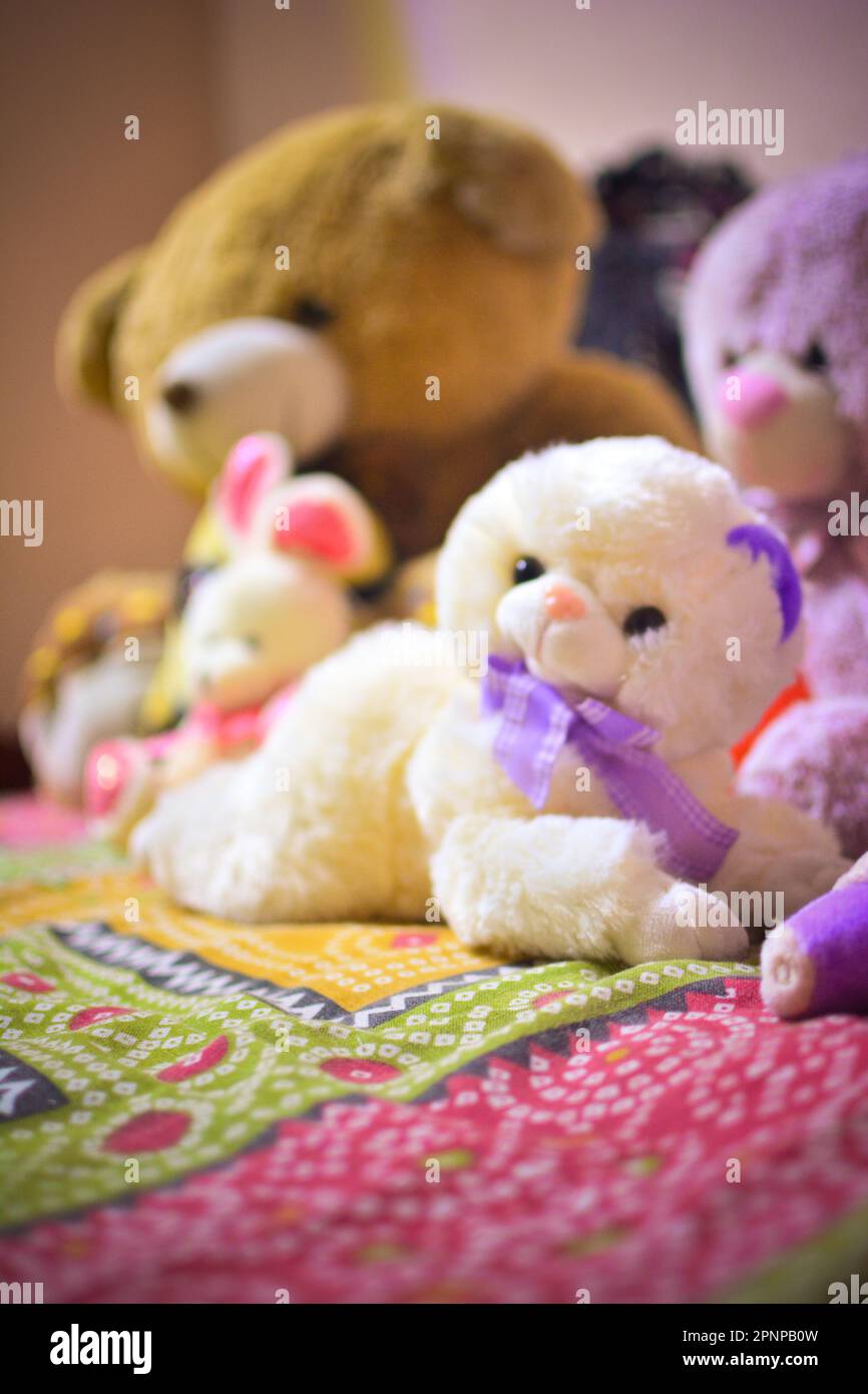 A cheerful group of teddy bears are snuggled up together on a bed