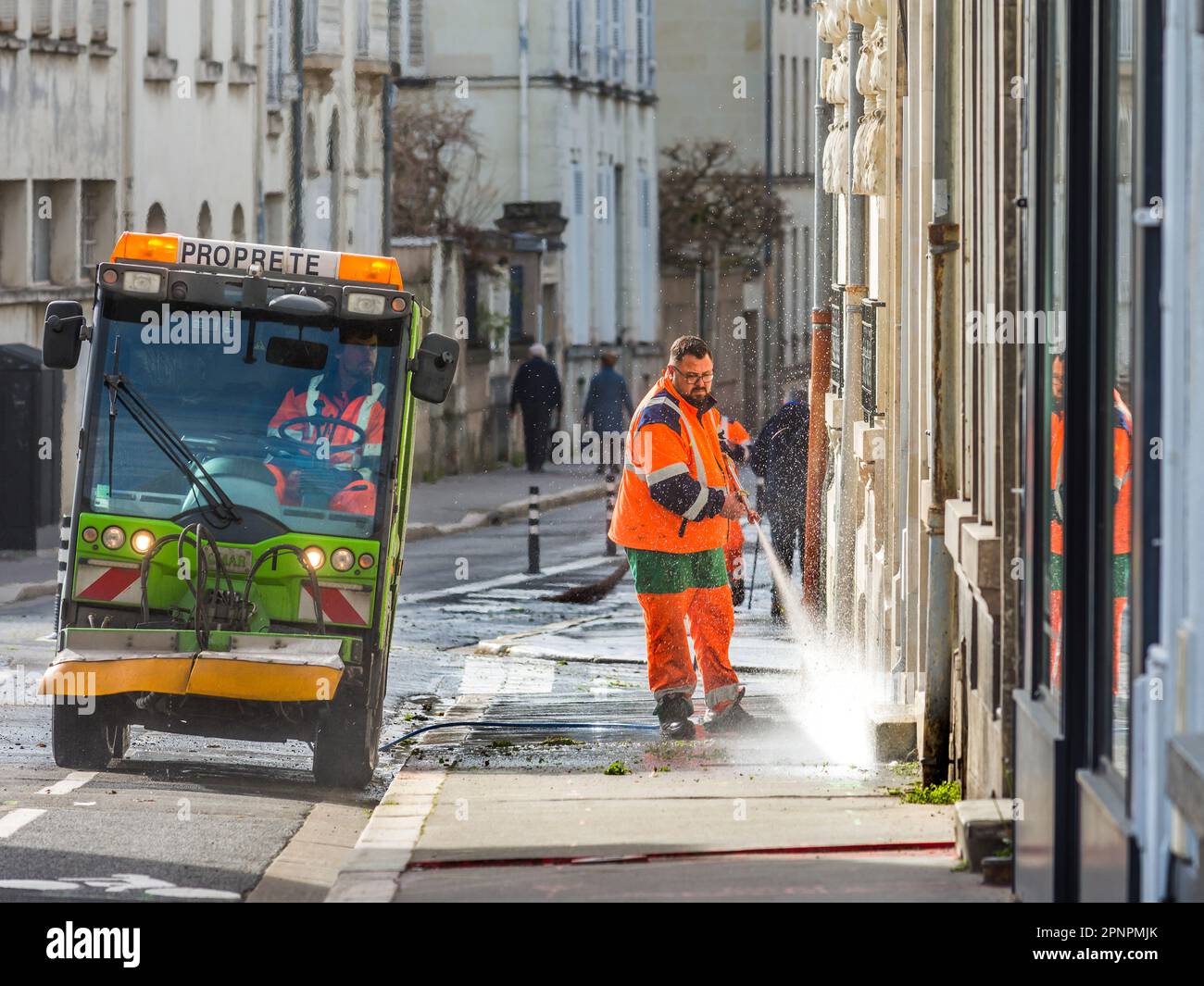Council workers cleaning pavement with water jet, Tours, Indre-et-Loire (37), France. Stock Photo