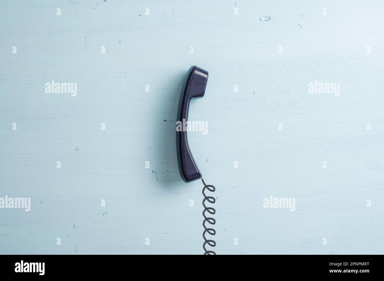 Black landline telephone receiver with a hand drawn cord attached to it