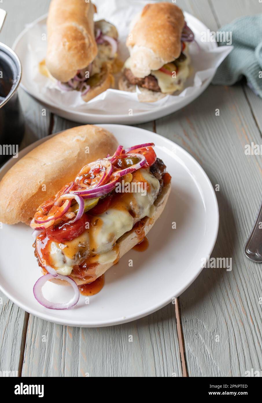 Burger sandwich with cheese, onions, tomatoes, pickles and homemade barbecue sauce Stock Photo