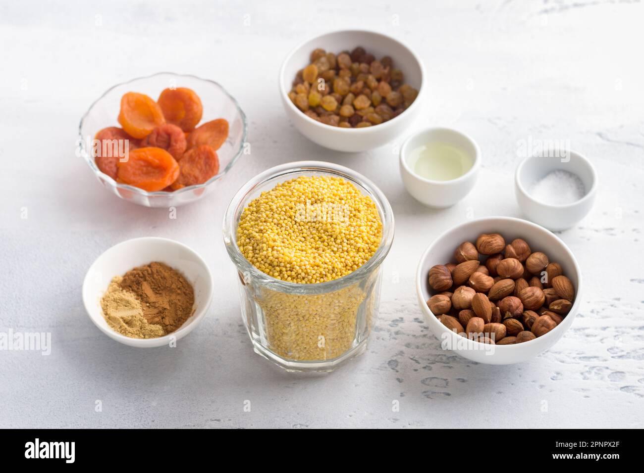 Ingredients for a vegan dish: cereals, casseroles and other dishes - millet, nuts (almonds, hazelnuts), dried apricots, raisins, spices (cinnamon, gin Stock Photo