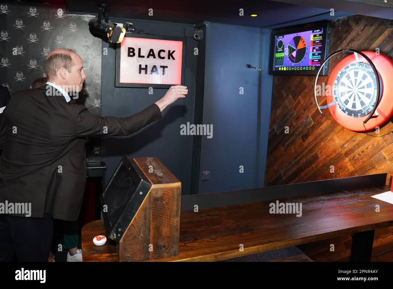 The Prince of Wales takes part in a game of interactive darts in the