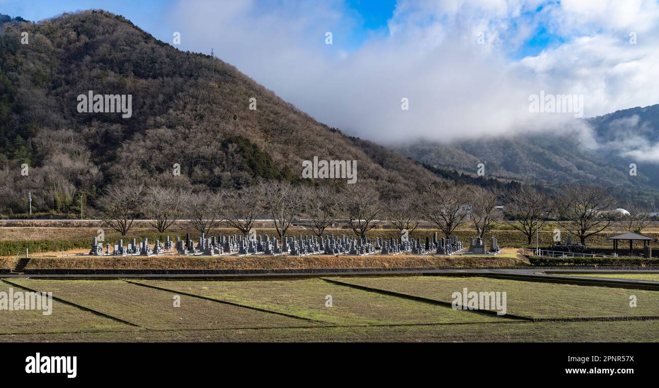 Farm fields and a cemetery seen from a JR West Kinosaki express train on the Sanin Main Line in Hyogo Prefecture, Japan. Stock Photo