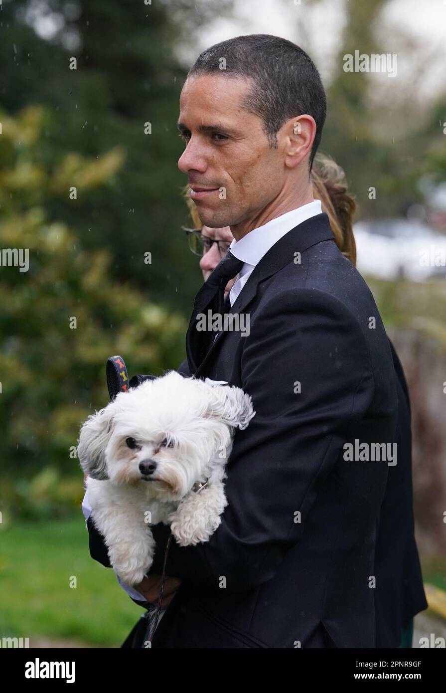 Husband of Paul O'Grady, Andre Portasio, carrying one of their dogs
