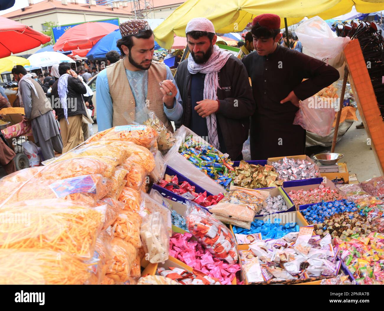 Kabul, Afghanistan. 18th Apr, 2023. Afghan people buy sweets at a
