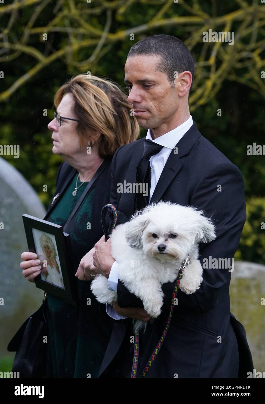 Husband of Paul O'Grady, Andre Portasio, carrying one of their dogs