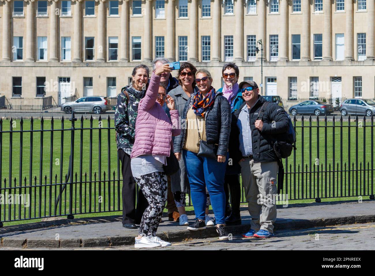 Bath, UK. 20th April, 2023. With forecasters predicting that cooler and more overcast weather is to come in the next few days, tourists are pictured as they take a group selfie in front of Bath's famous Royal Crescent. Credit: Lynchpics/Alamy Live News Stock Photo