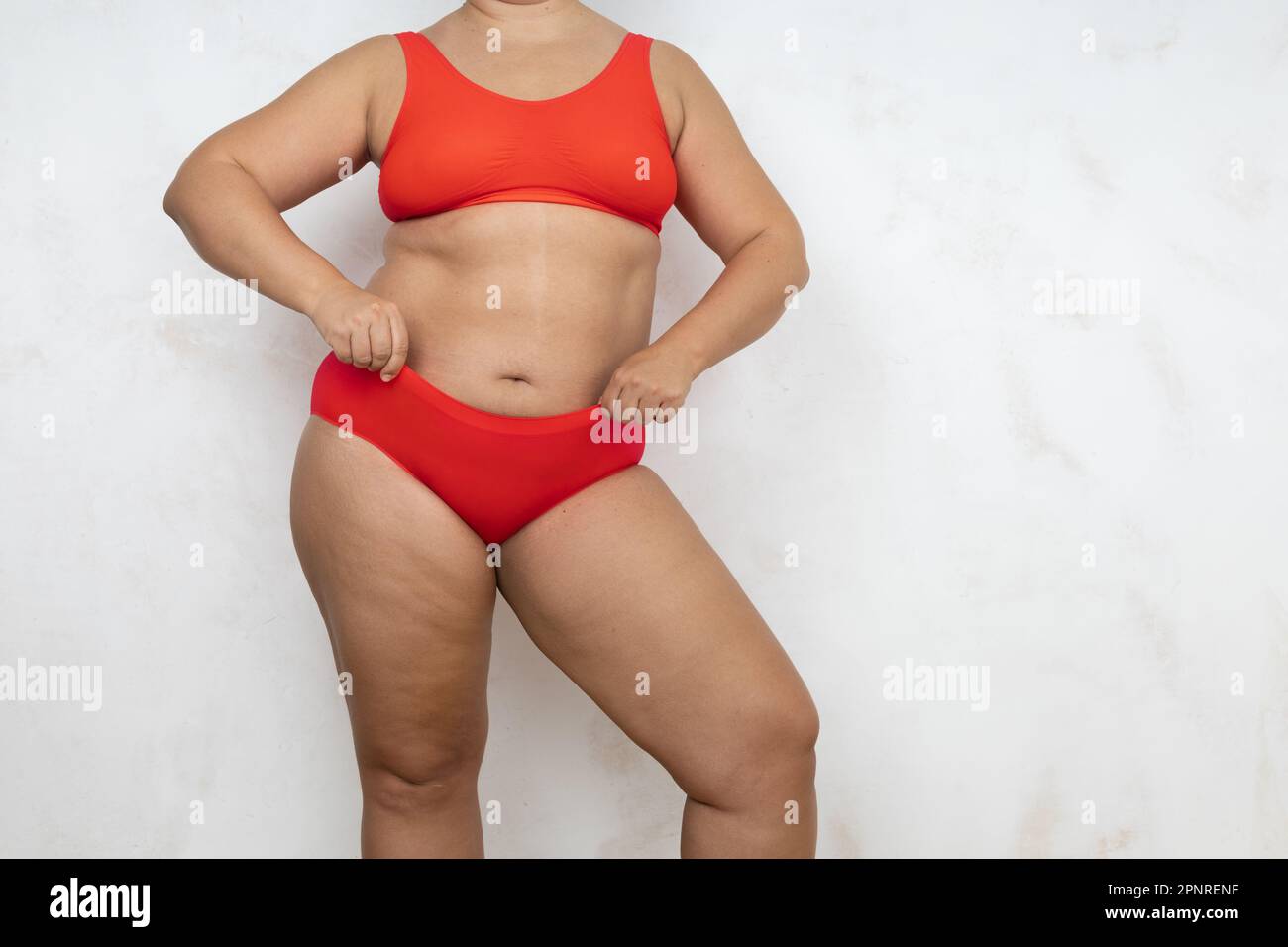 Overweight woman pull slimming underpants over large belly side