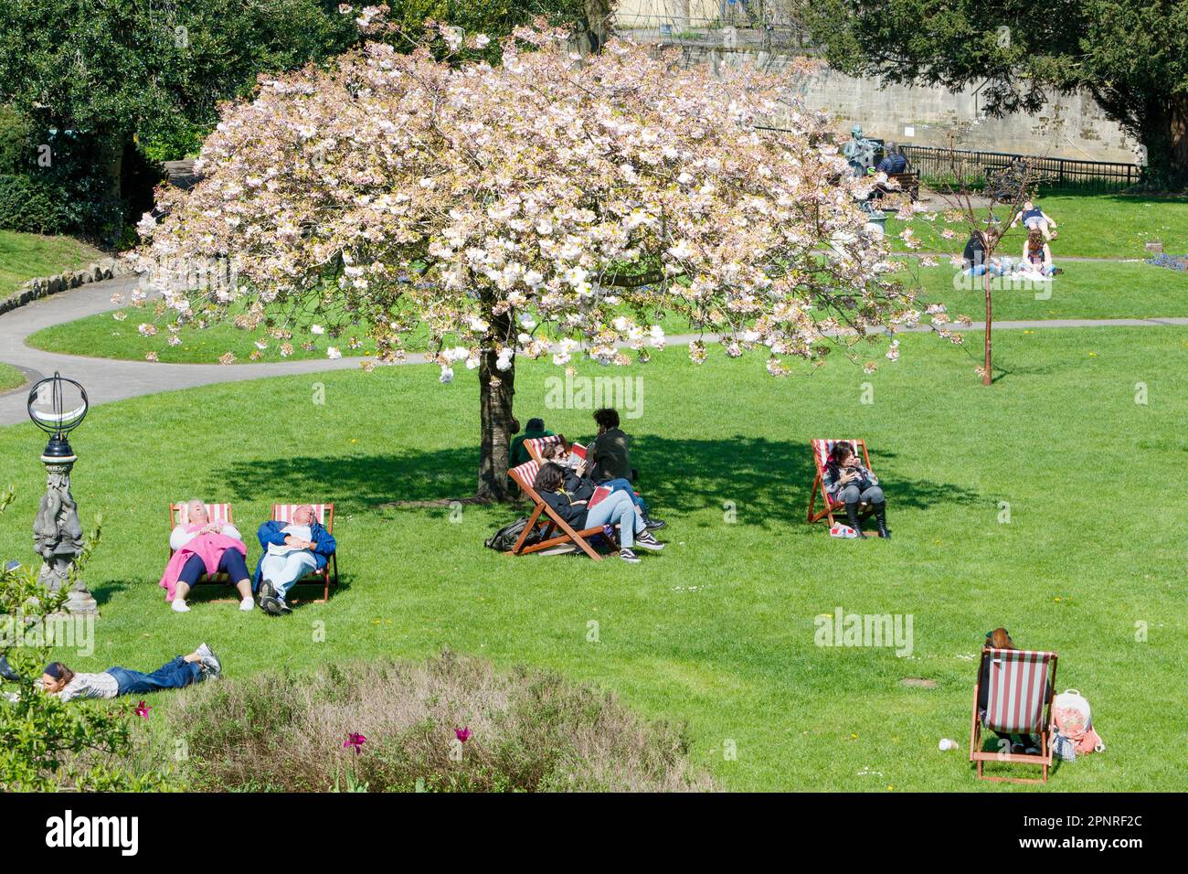 Bath, UK. 20th April, 2023. With forecasters predicting that cooler and more overcast weather is to come in the next few days, visitors to Bath's Parade Gardens are pictured taking advantage of the warm afternoon sunshine. Credit: Lynchpics/Alamy Live News Stock Photo