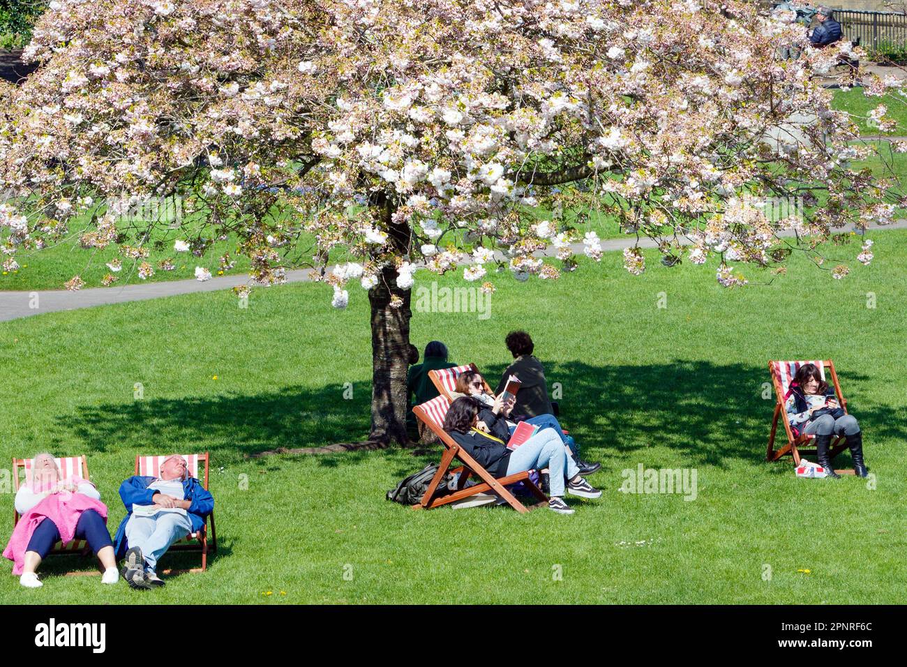 Bath, UK. 20th April, 2023. With forecasters predicting that cooler and more overcast weather is to come in the next few days, visitors to Bath's Parade Gardens are pictured taking advantage of the warm afternoon sunshine. Credit: Lynchpics/Alamy Live News Stock Photo