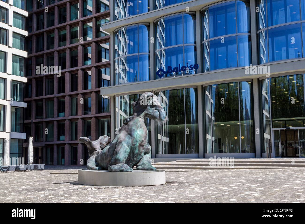 Basel, Switzerland -  August 10. 2021: The bronze imaginary snorting animal figure at the Baloise Park with high business buildings behind near the ce Stock Photo