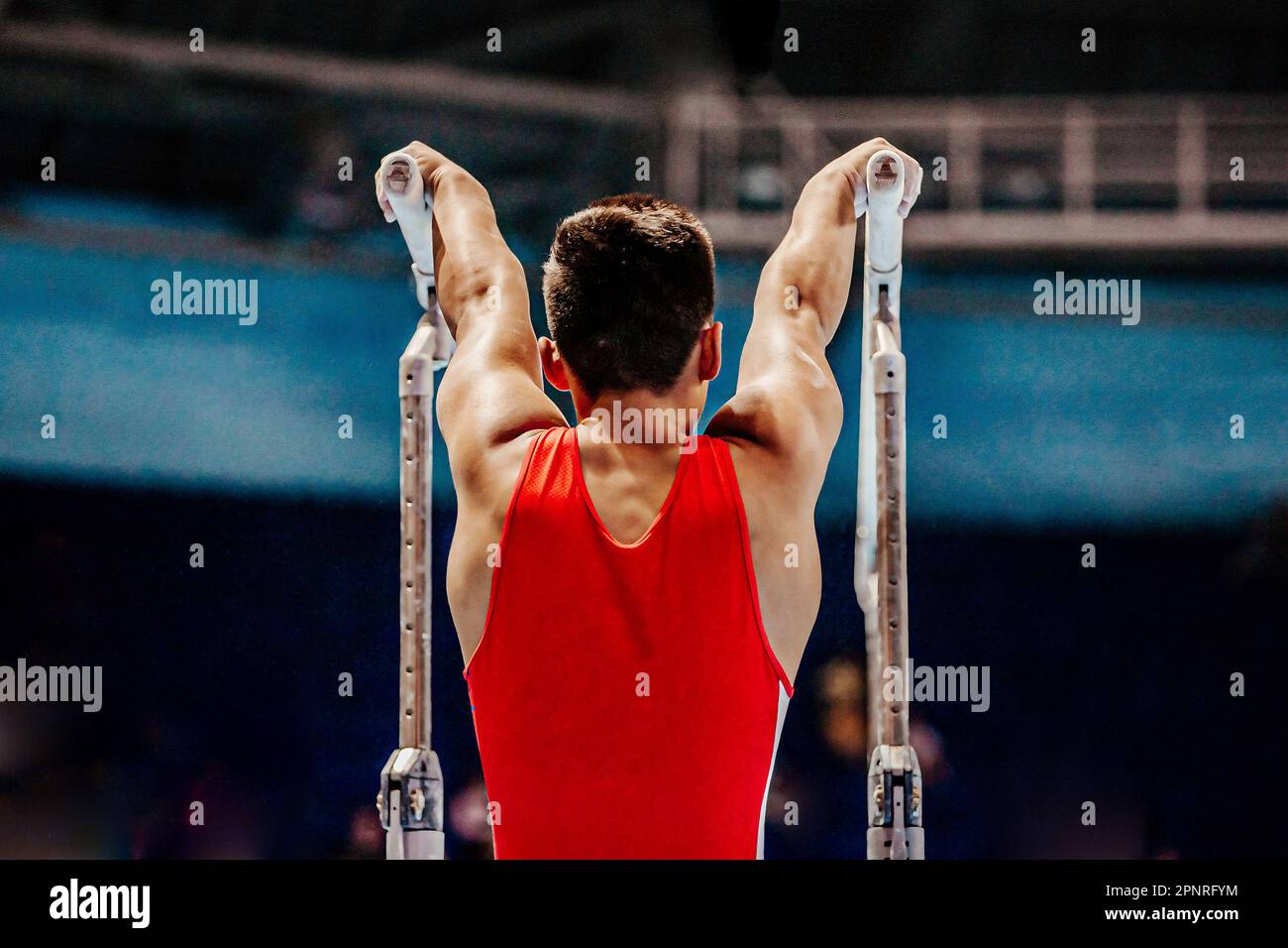 rear view athlete gymnast begin exercise parallel bars in championship gymnastics artistic Stock