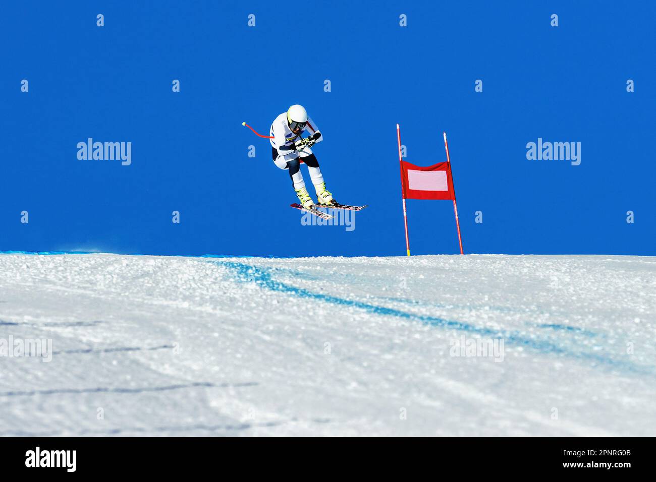 male ski racer on alpine skiing track downhill race, jump and flying on hill Stock Photo