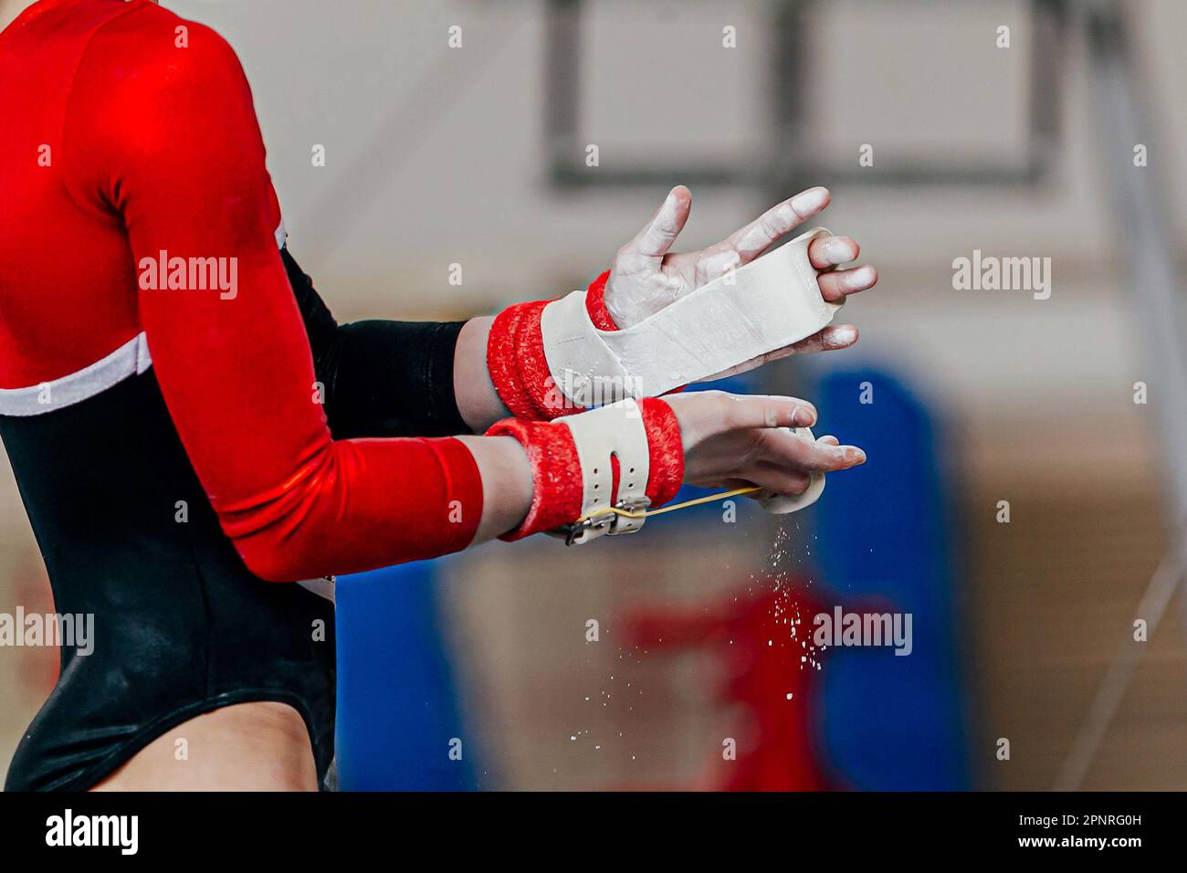 close-up hands female gymnast in gymnastics grips in gym chalk, uneven bars performing Stock Photo
