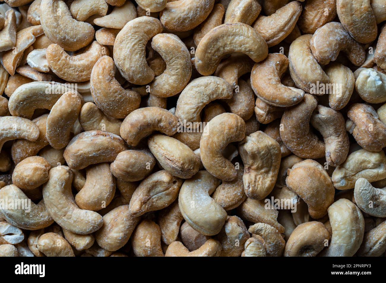 Pile cashew nuts without shell, close up, top view. Whole nut kernels Stock Photo