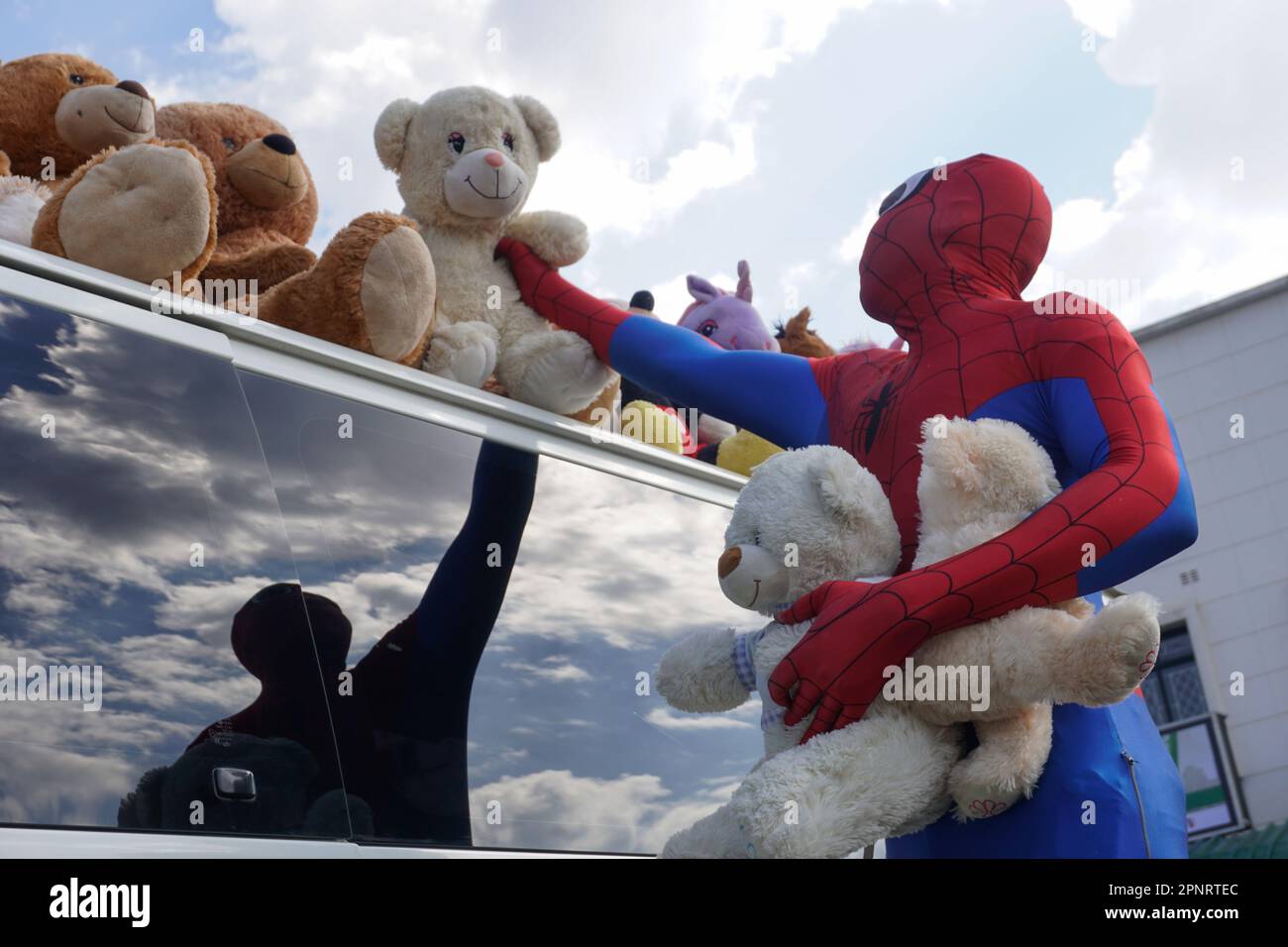 Farai Mabiza wears a Spiderman costume to attract customers to toy merchandise displayed on his car in Harare, Zimbabwe. Mabiza says his business has not been lucrative during the coronavirus pandemic since toys are a luxury for some. (Gamuchirai Masiyiwa/Global Press Journal) Stock Photo