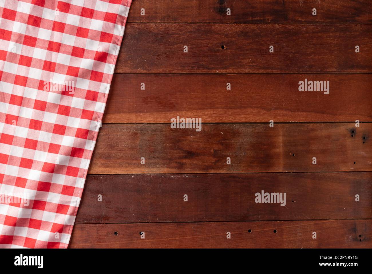 rustic wooden table background with red checkered tablecloth Stock Photo