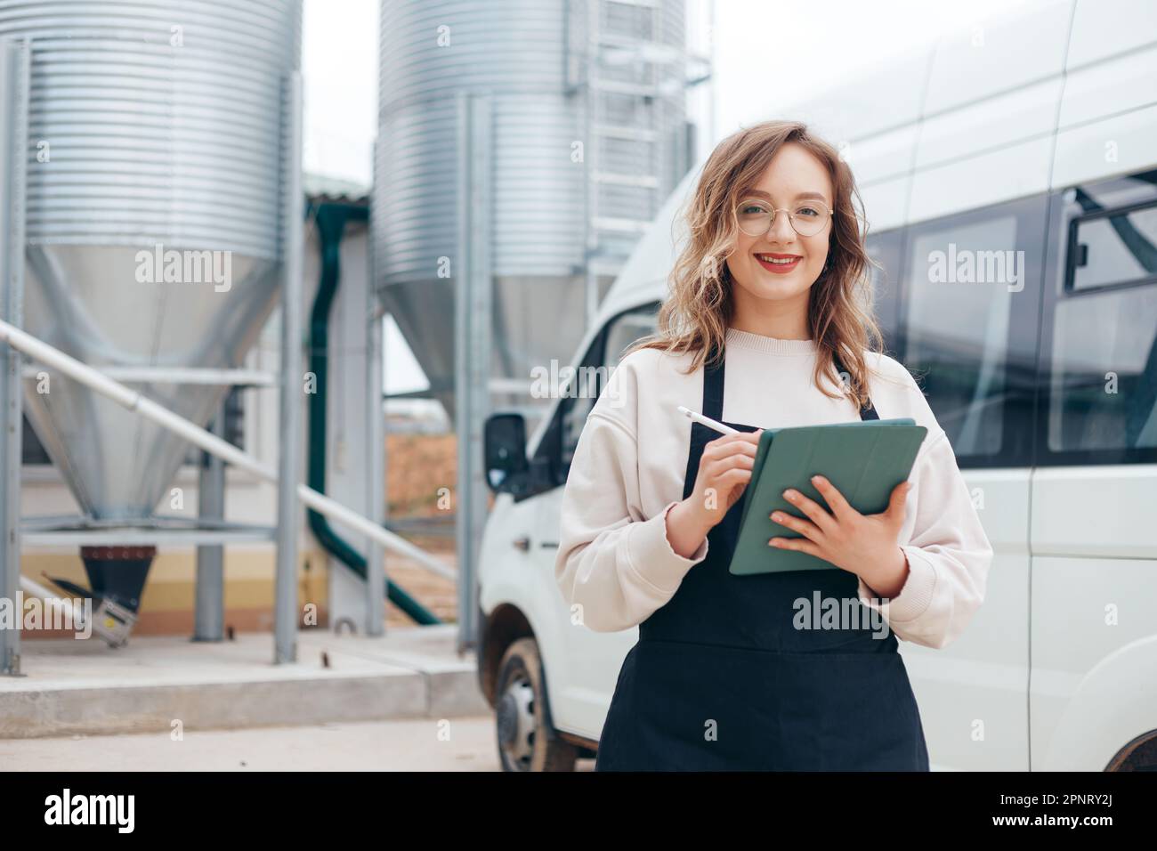 Woman Agricultural Engineer with Tablet Near Cyclone Industrial Equipment Stock Photo