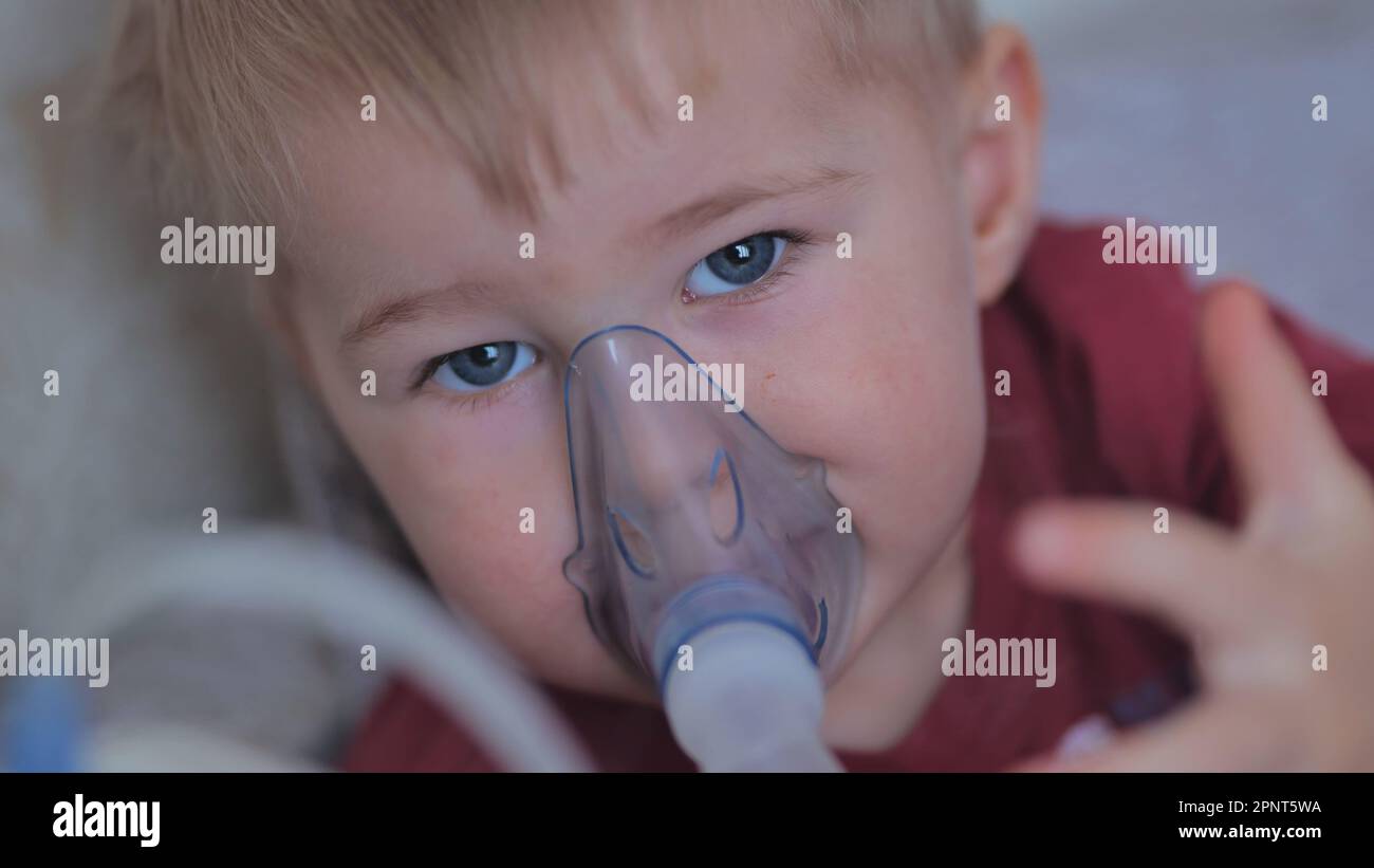 Funny boy breathing through an inhaler mask Stock Photo - Alamy