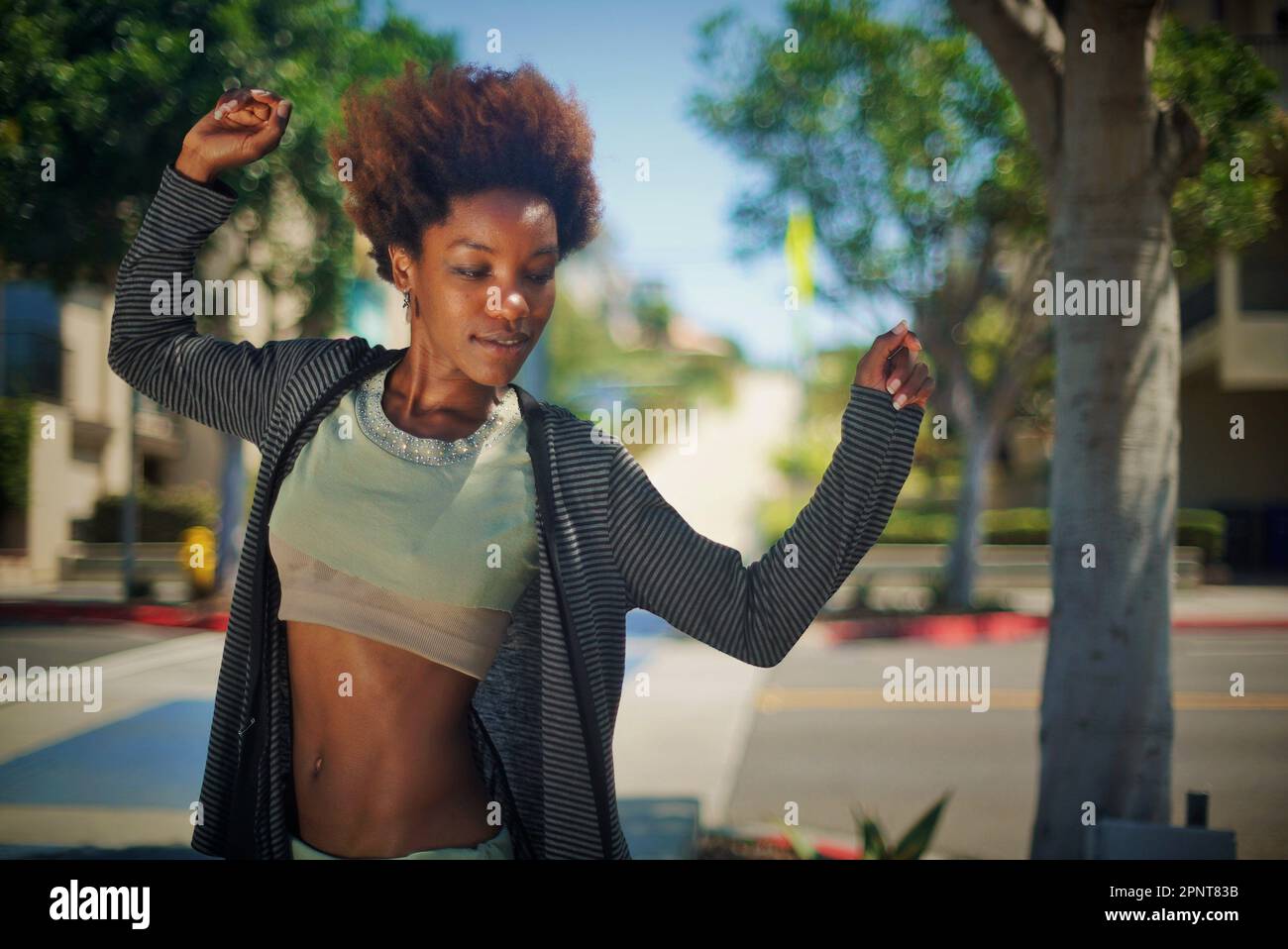 Beautiful Black woman standing on the sidewalk in Manhattan Beach, California on a summer day Stock Photo