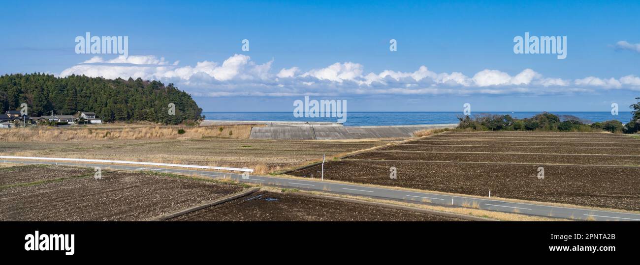 The Pacific Ocean coast with a concrete wall in Fukushima Prefecture, Japan, seen from a train on the JR East Joban Line. Stock Photo