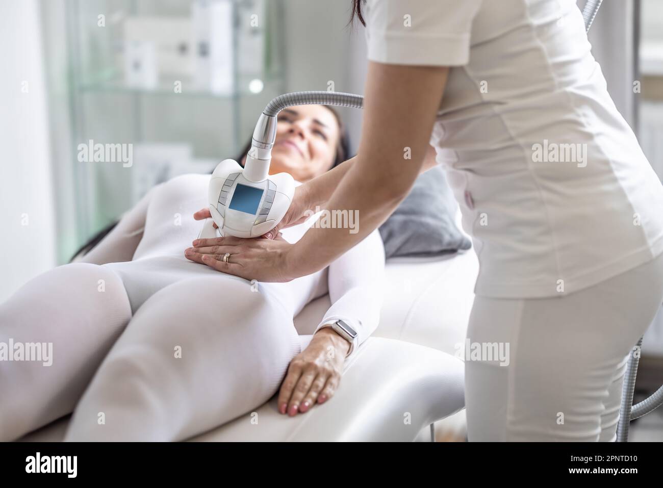 Female skincare treatment professional perform beautification procedure by a modern device. Stock Photo