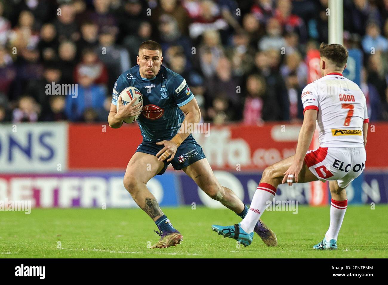 Greg Minikin 21 of Warrington Wolves side steps Lewis Dodd 7 of St
