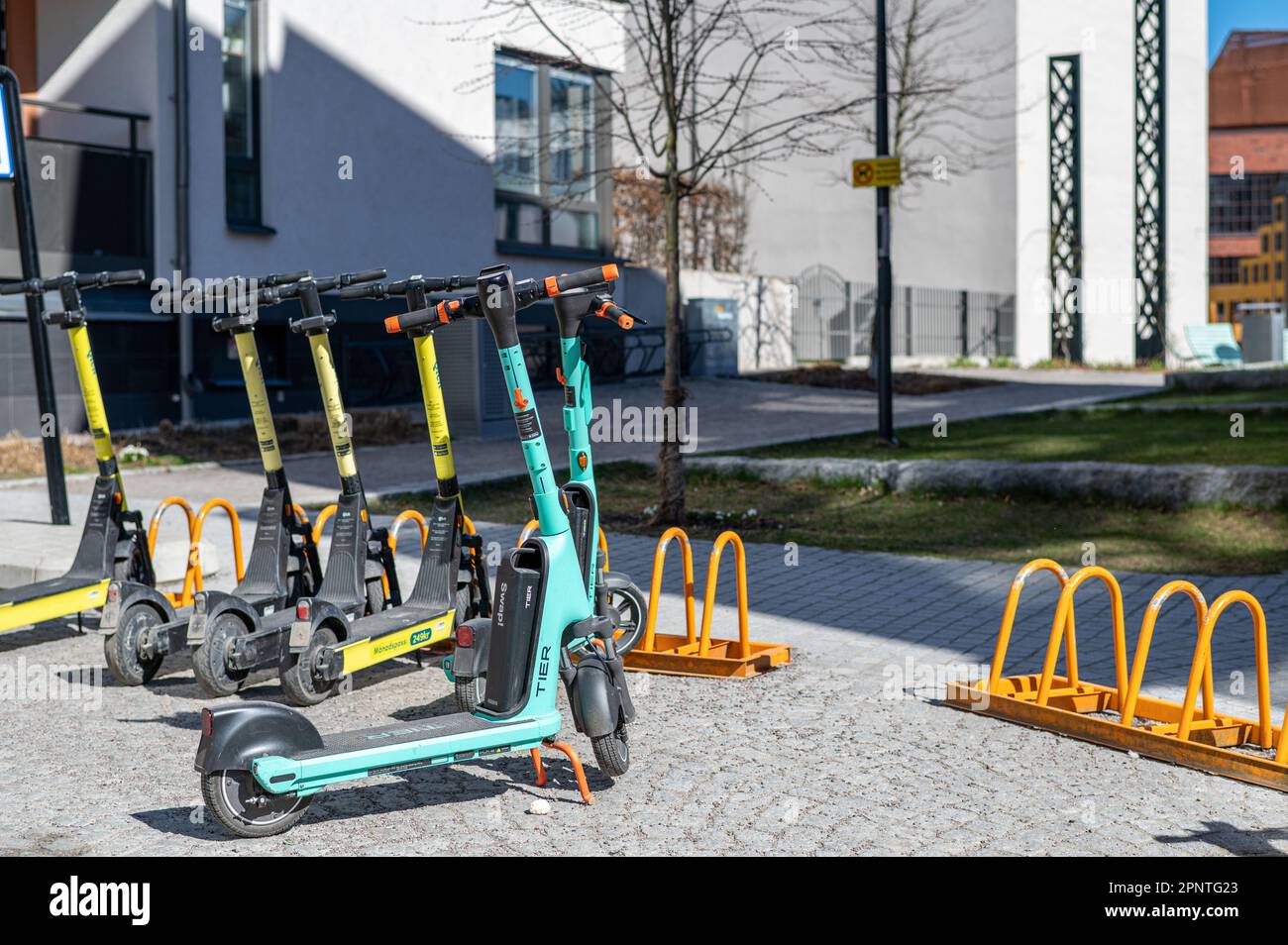 Electric scooters parked on a sidewalk in Norrköping, Sweden. These vehicles are controversial and recently Paris voted for a ban. Stock Photo