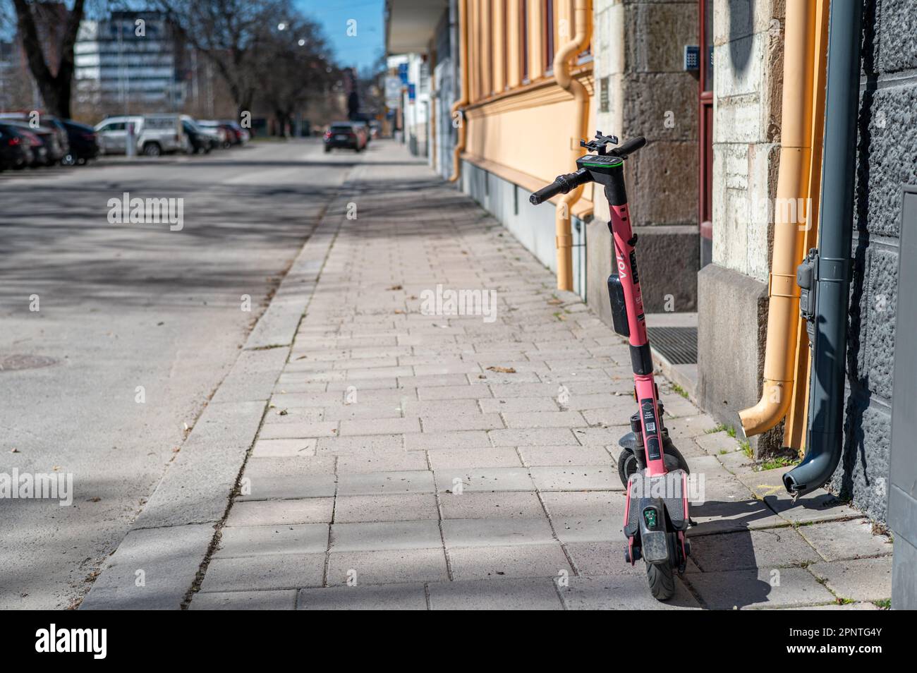 Electric scooters parked on a sidewalk in Norrkoping, Sweden. These